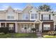 Charming townhome with rocking chairs on the porch, landscaped yard, and inviting curb appeal at 11023 Kinston Ridge Pl, Charlotte, NC 28273
