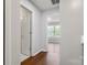 Bright hallway featuring hardwood floors, and white doors showcasing the home's neutral palette at 11023 Kinston Ridge Pl, Charlotte, NC 28273