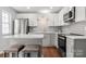 Updated kitchen with white cabinets, gray subway tile, granite countertops, and stainless steel appliances at 11023 Kinston Ridge Pl, Charlotte, NC 28273