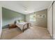 Neutrally painted bedroom with hanging plants, a bed, and natural lighting at 11834 Carmel Lakes Dr, Charlotte, NC 28226