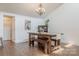 Bright dining room with hardwood floors, wooden table, chandelier, and vintage artwork at 11834 Carmel Lakes Dr, Charlotte, NC 28226