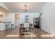 Dining room featuring hardwood floors, a chandelier, and access to other rooms at 11834 Carmel Lakes Dr, Charlotte, NC 28226