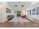 Open living area with hardwood floors, a stone fireplace, and ample natural light at 11834 Carmel Lakes Dr, Charlotte, NC 28226