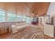 Bright sunroom with wood-paneled ceiling, large windows, and comfortable seating. Overlooks backyard at 11834 Carmel Lakes Dr, Charlotte, NC 28226
