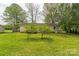 Spacious backyard with lush lawn, mature trees, and deck, great for outdoor enjoyment and relaxation at 120 Tower Dr, Statesville, NC 28677