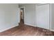 Bedroom features wood-look floors and neutral walls with an open doorway leading to a bathroom at 120 Tower Dr, Statesville, NC 28677