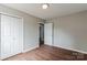 Bedroom with wood-look flooring, double-door closet, and fresh paint offers a clean and inviting space at 120 Tower Dr, Statesville, NC 28677