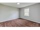 Bright bedroom features wood-look floors, fresh paint, a modern light fixture, and a window offering natural light at 120 Tower Dr, Statesville, NC 28677