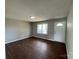 Cozy living room with hardwood floors, a bright window, and a white front door at 120 Tower Dr, Statesville, NC 28677