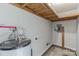 Unfinished utility room with exposed ceiling, water heater, and electrical panel offers storage space and functionality at 120 Tower Dr, Statesville, NC 28677