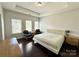 Spacious bedroom with tray ceiling, two chairs by the windows, and hardwood floors at 12421 Fiorentina St, Charlotte, NC 28277