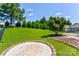 Lush backyard with a manicured lawn, mature trees, a stone-lined fire pit, and a paver patio at 1325 Grantwood Nw Ave, Concord, NC 28027