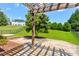 Beautiful backyard with a paver patio, pergola, lush green lawn, and mature trees at 1325 Grantwood Nw Ave, Concord, NC 28027