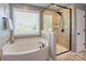 An en-suite bathroom features a soaking tub and glass enclosed shower at 1325 Grantwood Nw Ave, Concord, NC 28027