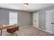 Cozy bedroom featuring neutral walls, carpet, a window, closet, and a wooden desk with chair at 1325 Grantwood Nw Ave, Concord, NC 28027