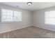 An empty bedroom with neutral carpet and two windows that let in lots of natural light at 1325 Grantwood Nw Ave, Concord, NC 28027