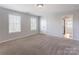 A spacious bedroom with neutral carpet and multiple windows to let in natural light at 1325 Grantwood Nw Ave, Concord, NC 28027