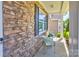 Charming covered front porch featuring stone accents, adorned with two chairs for relaxing at 1325 Grantwood Nw Ave, Concord, NC 28027