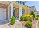 Inviting front entrance with stone facade, manicured bushes, and a covered porch leading to the front door at 1325 Grantwood Nw Ave, Concord, NC 28027