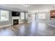Open-concept living room with a cozy fireplace, wood floors, and lots of natural light at 1325 Grantwood Nw Ave, Concord, NC 28027