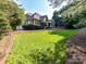 Expansive backyard with lush green grass, mature trees, and a well-maintained lawn at 15009 Fanning Manor Ct, Charlotte, NC 28277