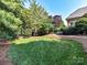 Lush backyard featuring a manicured lawn and mature trees at 15009 Fanning Manor Ct, Charlotte, NC 28277