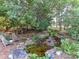 Beautiful backyard features a tranquil pond with a waterfall and seating area at 15009 Fanning Manor Ct, Charlotte, NC 28277