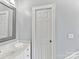 Clean bathroom featuring a vanity with a white countertop, a large mirror, and a white door at 15009 Fanning Manor Ct, Charlotte, NC 28277