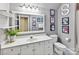 Well-lit bathroom features a white vanity, framed mirror, magazine-themed art, and toilet at 15009 Fanning Manor Ct, Charlotte, NC 28277