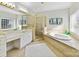 Elegant bathroom featuring a glass-enclosed shower, soaking tub, dual vanity, and picture window at 15009 Fanning Manor Ct, Charlotte, NC 28277