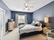 Inviting bedroom with neutral tones, soft bedding, a ceiling fan, and ample natural light at 15009 Fanning Manor Ct, Charlotte, NC 28277