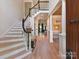 Spacious foyer with staircase and columns, showcasing light wood floors and an open floor plan at 15009 Fanning Manor Ct, Charlotte, NC 28277