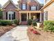 Charming brick home with a landscaped walkway leading to the columned front entrance and a lovely garden at 15009 Fanning Manor Ct, Charlotte, NC 28277