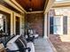 Inviting covered front porch with comfortable seating, brick walls, and stylish decor at 15009 Fanning Manor Ct, Charlotte, NC 28277