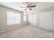 Bright bedroom featuring multiple windows, closets, and neutral carpeting at 17431 Tuscany Ln, Cornelius, NC 28031