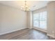 Dining room featuring modern chandelier, wood floors, and a bright window at 17431 Tuscany Ln, Cornelius, NC 28031