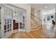 Bright entryway featuring wood floors, a staircase with white railings, and french doors leading to an office at 2000 Taney Way, Indian Land, SC 29707