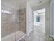 Shower with glass door, tile surround, and in-shower shelving at 2000 Taney Way, Indian Land, SC 29707