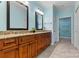 Bright bathroom boasts double sinks, dark wood cabinets, granite countertops and a view to Primary bedroom at 2369 Stardust Ct, Denver, NC 28037