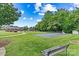 Outdoor tennis court with green surface, surrounded by lush trees, located within a well-maintained community at 2369 Stardust Ct, Denver, NC 28037