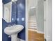 Modern powder room with pedestal sink and stylish blue walls, adding a touch of elegance at 25391 Seagull Dr, Lancaster, SC 29720