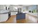 Modern kitchen with stainless steel appliances, gray island, white cabinets and stylish backsplash at 25391 Seagull Dr, Lancaster, SC 29720