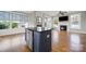 Open concept living room showcasing hardwood floors, fireplace, large windows and granite-topped island at 25391 Seagull Dr, Lancaster, SC 29720