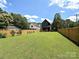 Spacious backyard with a well-maintained lawn, a fire pit area, and a wooden fence for privacy at 2553 Elkwood Cir, Charlotte, NC 28205