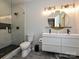 Modern bathroom with double vanity, round mirror, and a walk-in shower with stylish tile design at 2553 Elkwood Cir, Charlotte, NC 28205