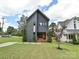 Modern two-story home featuring sleek gray siding, a stylish wood-accented entrance, and well-manicured lawn at 2553 Elkwood Cir, Charlotte, NC 28205
