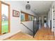 Second story hallway with hardwood floors, metal railings, and big windows providing plenty of natural light at 2553 Elkwood Cir, Charlotte, NC 28205