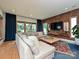 Cozy living room with a large sectional couch, wood paneling, and a view to the outside greenery at 2553 Elkwood Cir, Charlotte, NC 28205