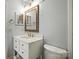 This white-toned bathroom has an ornate mirror at 3020 Heathstead Pl # A, Charlotte, NC 28210