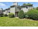 Exterior view of the condo featuring a well-maintained lawn and small second story balcony at 3020 Heathstead Pl # A, Charlotte, NC 28210